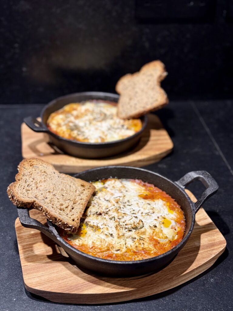 two bowls of food on a wooden surface